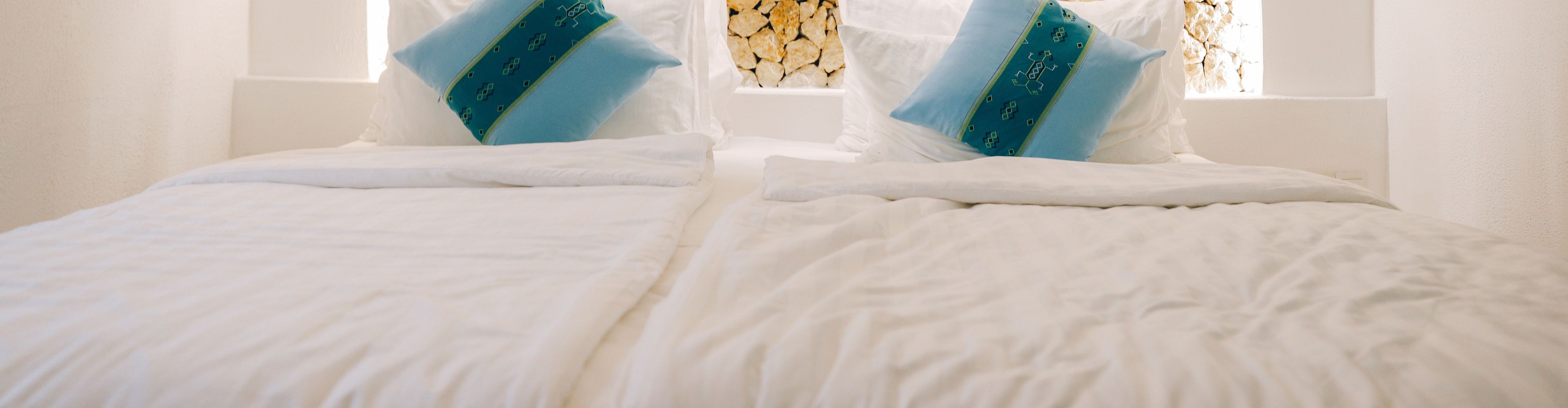 Hotel bed with blue embroidered cushions