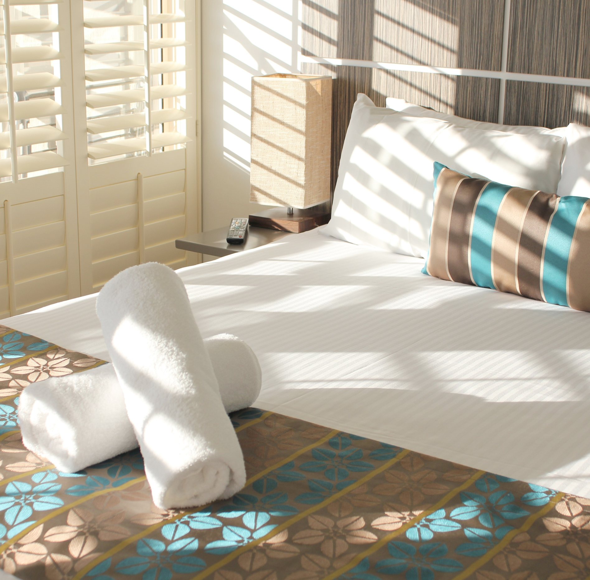 Resort bed with towels and coastal styling
